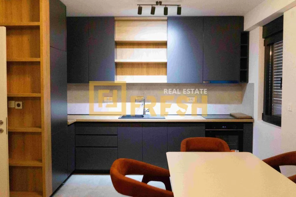 Modern kitchen with dark cabinetry and a dining table.