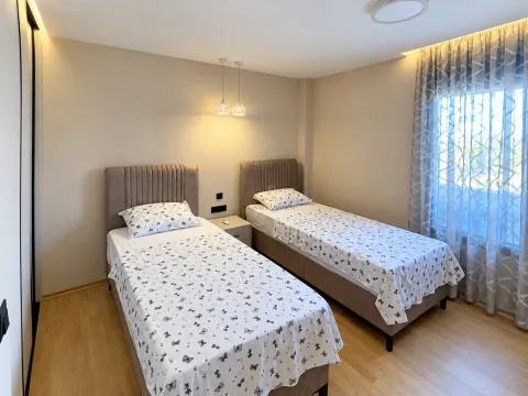 Bedroom with two single beds and a nightstand. - image 10