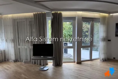 Dnevni boravak sa parketom, velikim prozorima i televizorom. - image 7