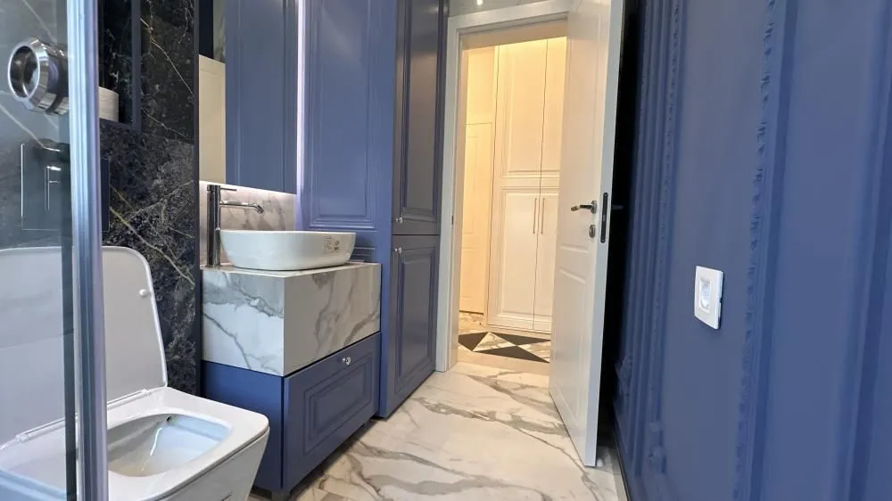 Moderno opremljeno kupatilo sa umivaonikom i wc šoljom.