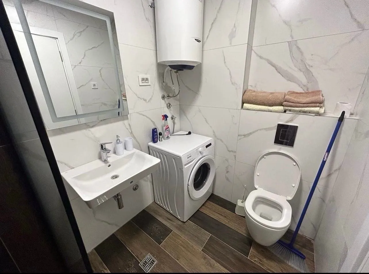 Modernly equipped bathroom with sanitary fixtures, washbasin, and washing machine.
