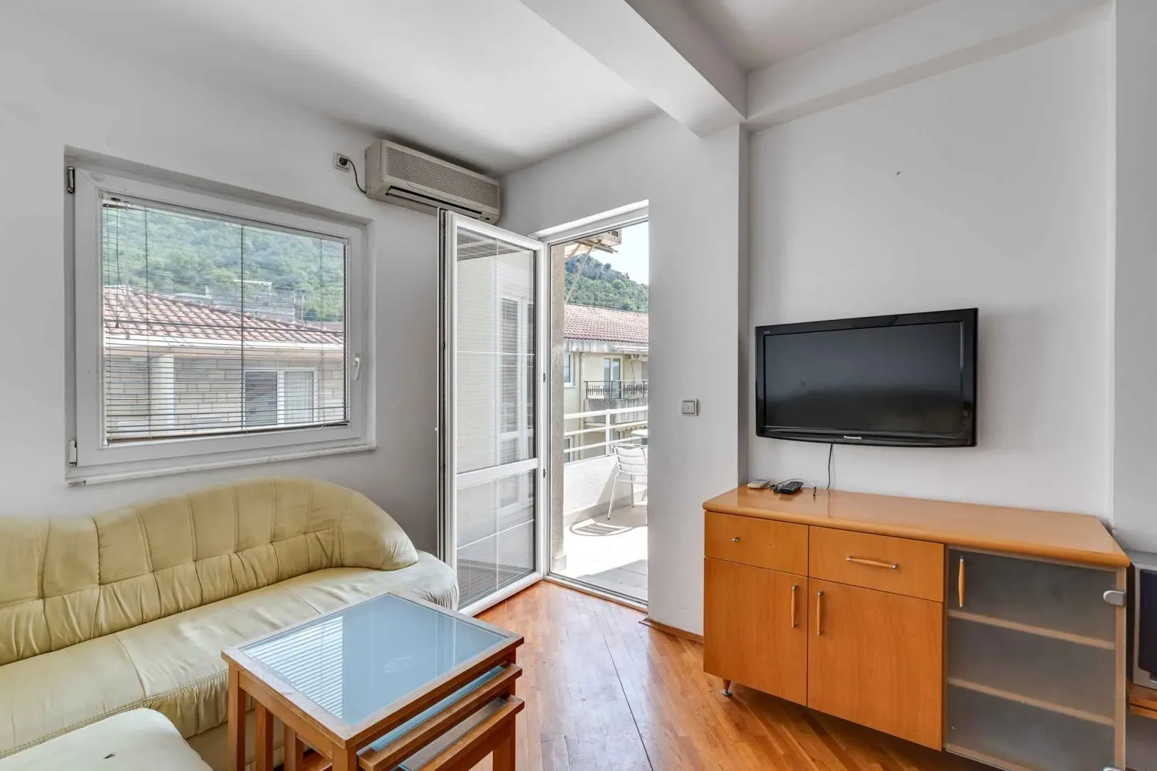 Living room with a sofa, TV cabinet, and access to the terrace.