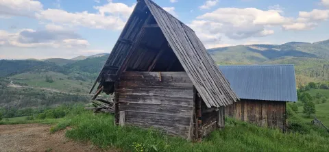 Stare drvene kolibe na brdu okružene prirodom i planinskim pejzažem. - image 8