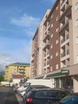 Pogled na spoljašnjost stambene zgrade sa parkingom ispred. - image 5