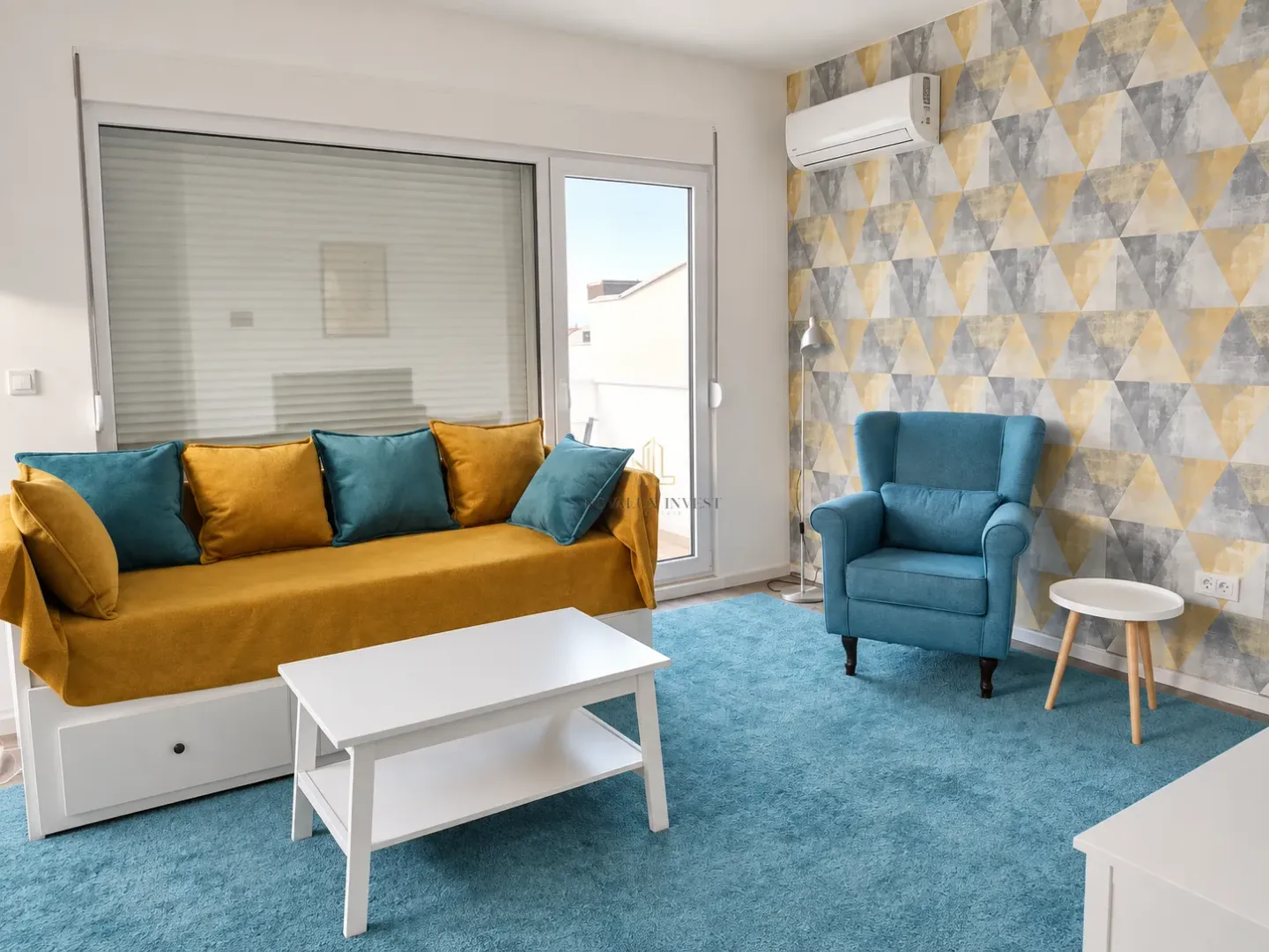 Living room with a yellow sofa, a blue armchair and access to the terrace.