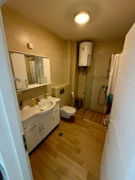 Pregledno opremljeno kupatilo sa tuš kabinom i bijelim kupatilskim namještajem. - image 6
