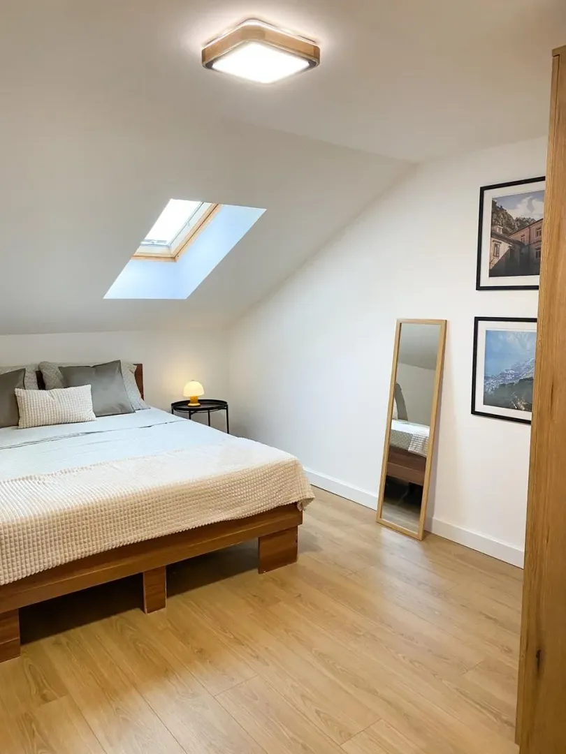 Bedroom with a double bed and a roof window in the attic.