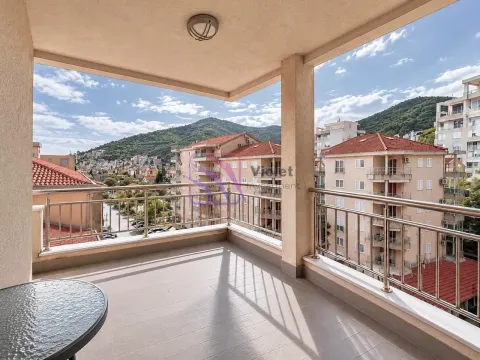 Covered balcony with a metal railing and views of the city and mountains. - image 7