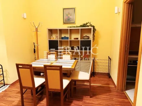 Dining area with a wooden table, chairs, and shelving unit in an apartment. - image 5
