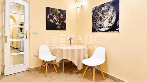 Manja trpezarija sa stolom, stolicama i umetničkim slikama na zidu. - image 3