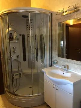 A bathroom featuring a shower cabin, sink, and mirror. - image 29