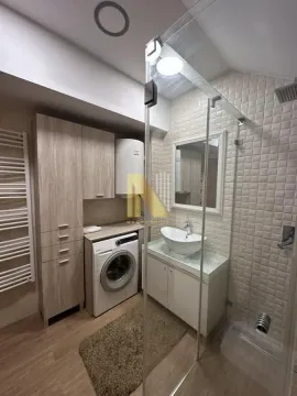 Savremeno opremljeno kupatilo sa tuš kabinom, umivaonikom i veš mašinom. - image 13