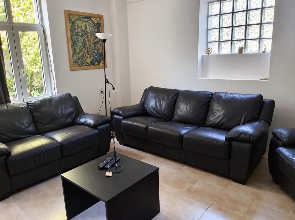 Living room with black leather sofas and a coffee table.