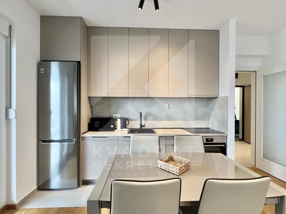 Modern kitchen with built-in units and a dining table.