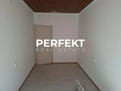 Prazna soba sa drvenim plafonom i svetlim zidovima. - image 4