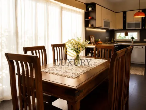 Dining area with a wooden table and chairs, connected to the kitchen. - image 12