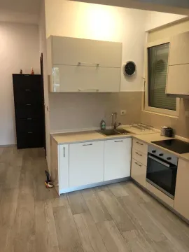 Small kitchen with light-colored cabinets and built-in appliances. - image 12