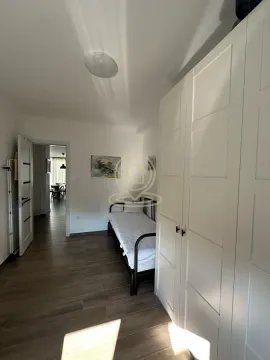 Manja spavaća soba sa krevetom i belim ormarom. - image 3