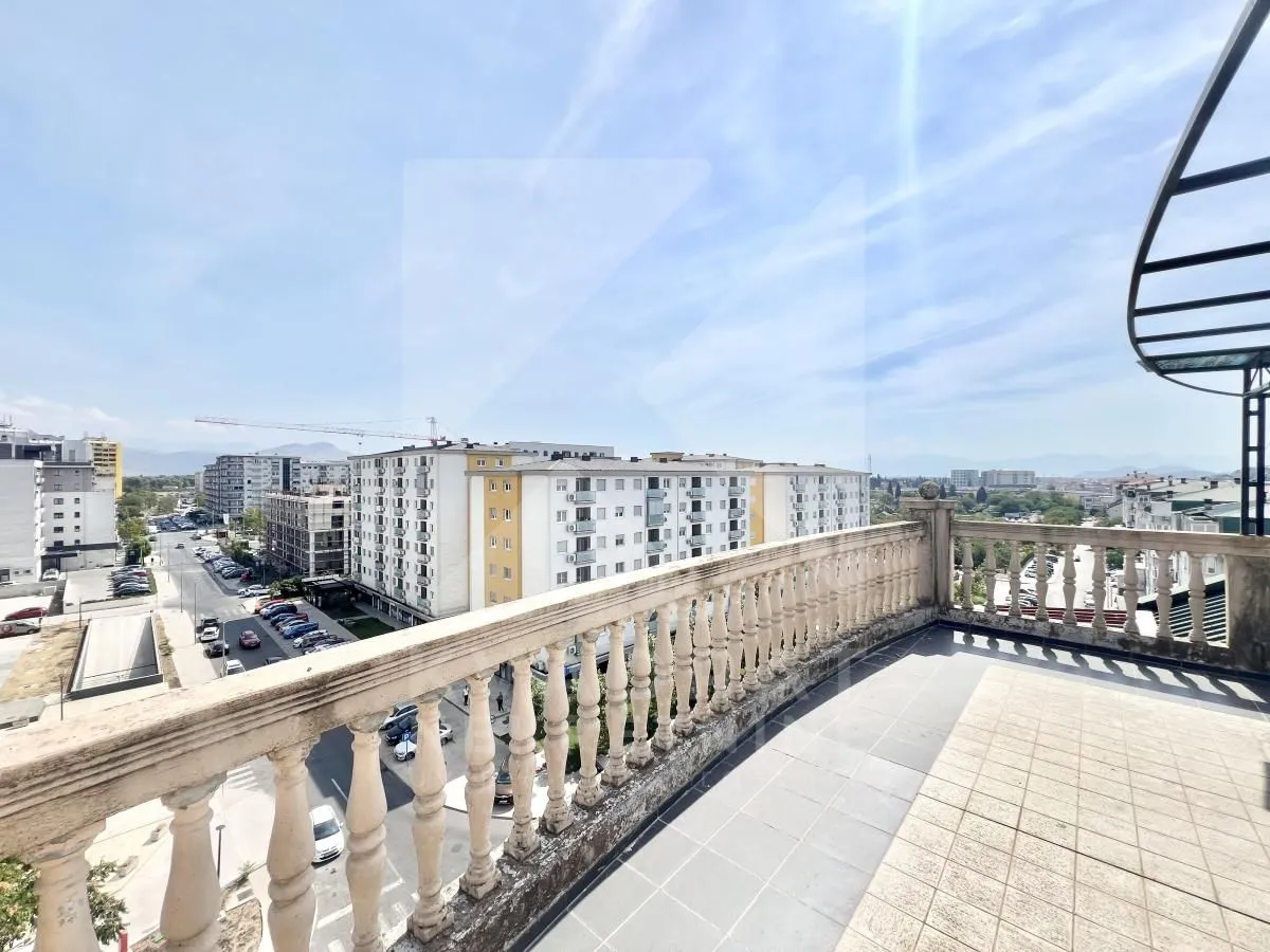 Spacious terrace with a stone balustrade and city views.