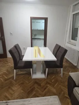 Trpezarija sa stolom i stolicama i pogledom na kuhinju. - image 4