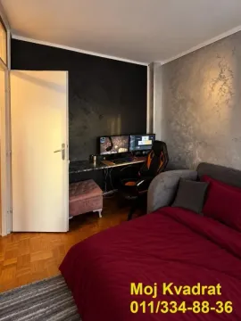 Bedroom with a bed and a desk with a computer setup. - image 12