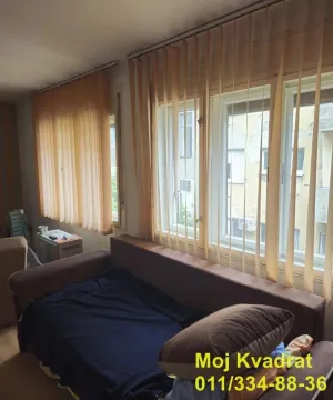 Dnevna soba sa kaučem i prozorima sa vertikalnim žaluzinama. - image 3