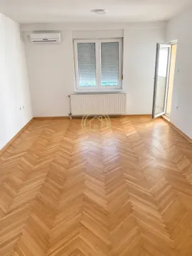 Prazna soba sa parketom, klima uređajem i izlazom na terasu. - image 2