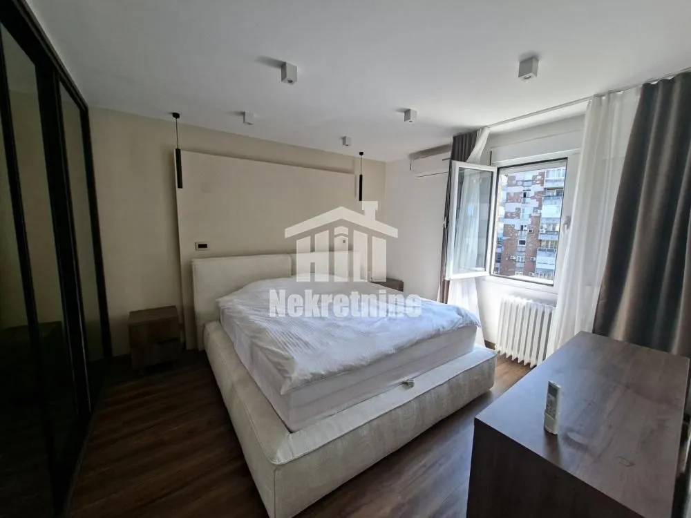 Furnished bedroom with a double bed, wardrobe, and a window.