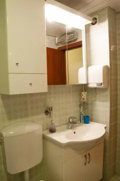 A bathroom with a sink and mirror. - image 7