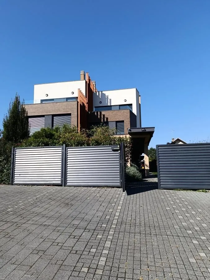View of the exterior of the building with a yard and fence.
