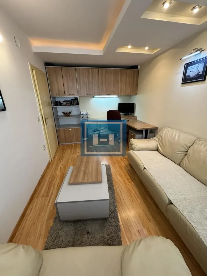 Small living room with a sofa, coffee table, and a desk against the wall.
