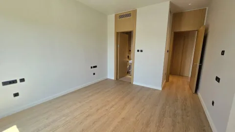 Prazna soba sa svijetlim drvenim podom i bijelim zidovima. - image 7