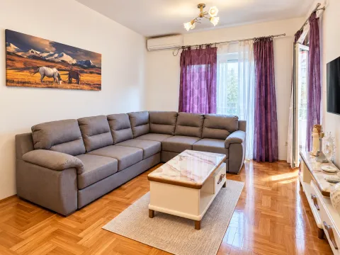 Living room with a sectional sofa, coffee table, and TV. - image 2