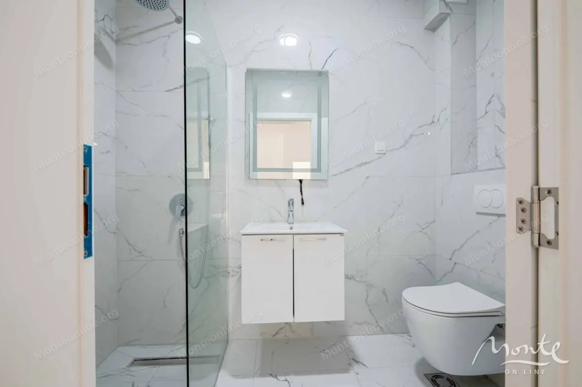 Moderne kupatilo sa tuš kabinom, umivaonikom i wc šoljom.