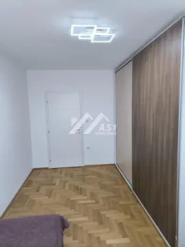 Smaller room with a large built-in wardrobe and parquet flooring. - image 7