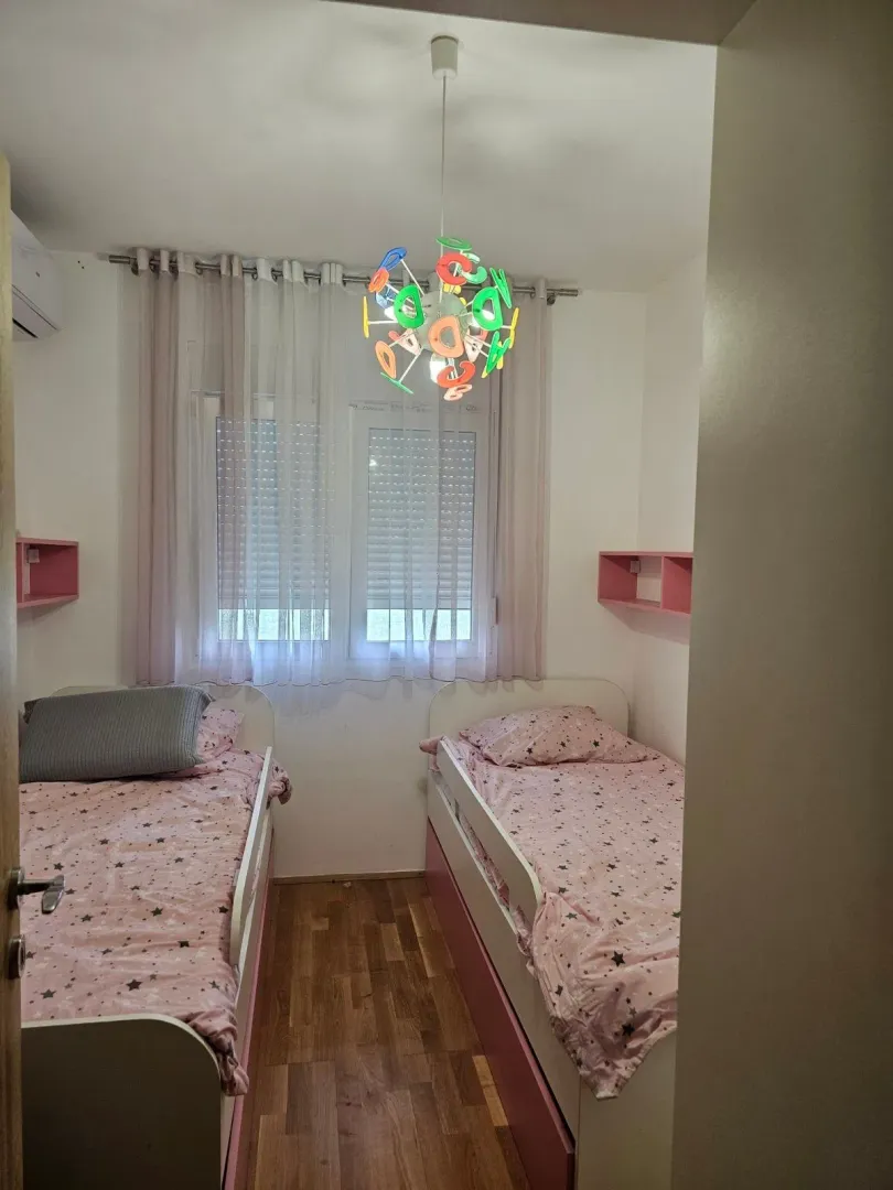 Dječija soba sa dva kreveta i prozorom.