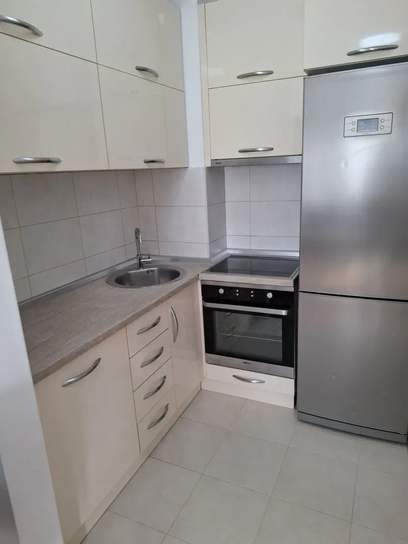 Bright kitchen with built-in cabinets and a stainless steel refrigerator.