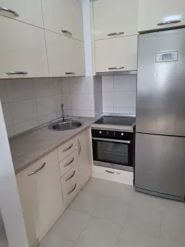 Bright kitchen with built-in cabinets and a stainless steel refrigerator. - image 10