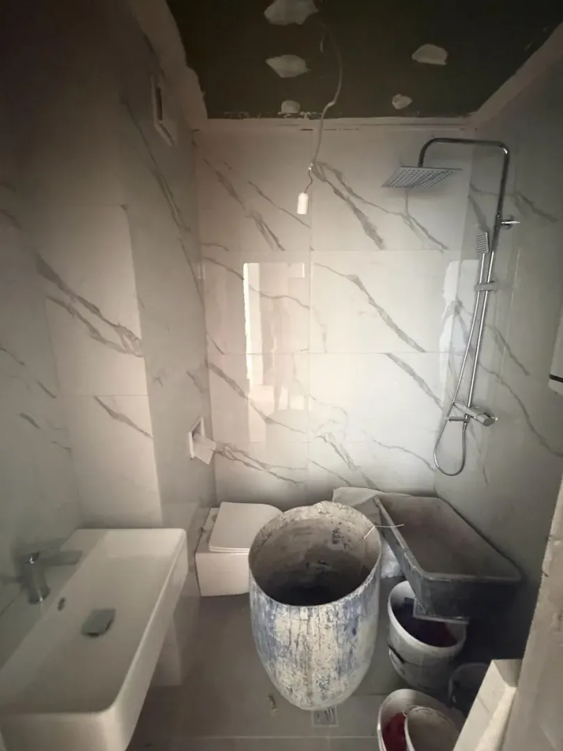 Kupatilo u fazi završnih radova sa sanitarijama i građevinskim materijalom.