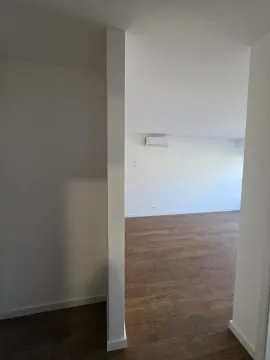Pogled iz hodnika na praznu prostoriju sa parketom i klima uređajem. - image 7