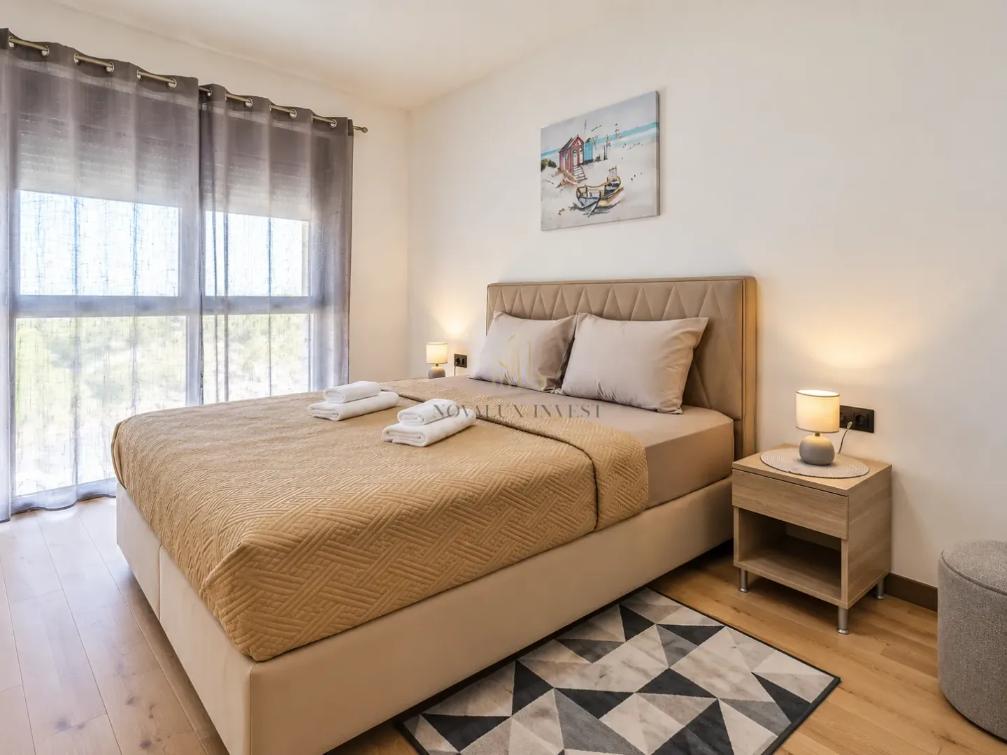 Spacious bedroom with a double bed, bedside tables, and a window.