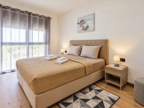 Spacious bedroom with a double bed, bedside tables, and a window. - image 8