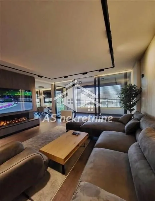 Modern living room with a sectional sofa, wooden coffee table, and television.