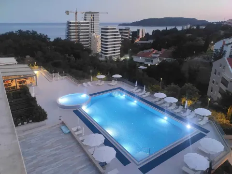 Aerial view of an outdoor swimming pool with sun loungers and umbrellas. - image 7