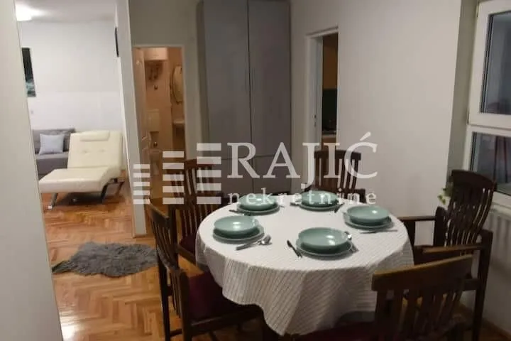Dining area with a table and chairs and a view of the living room.