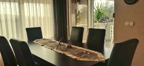 Dining room with a large table and black chairs. - image 4