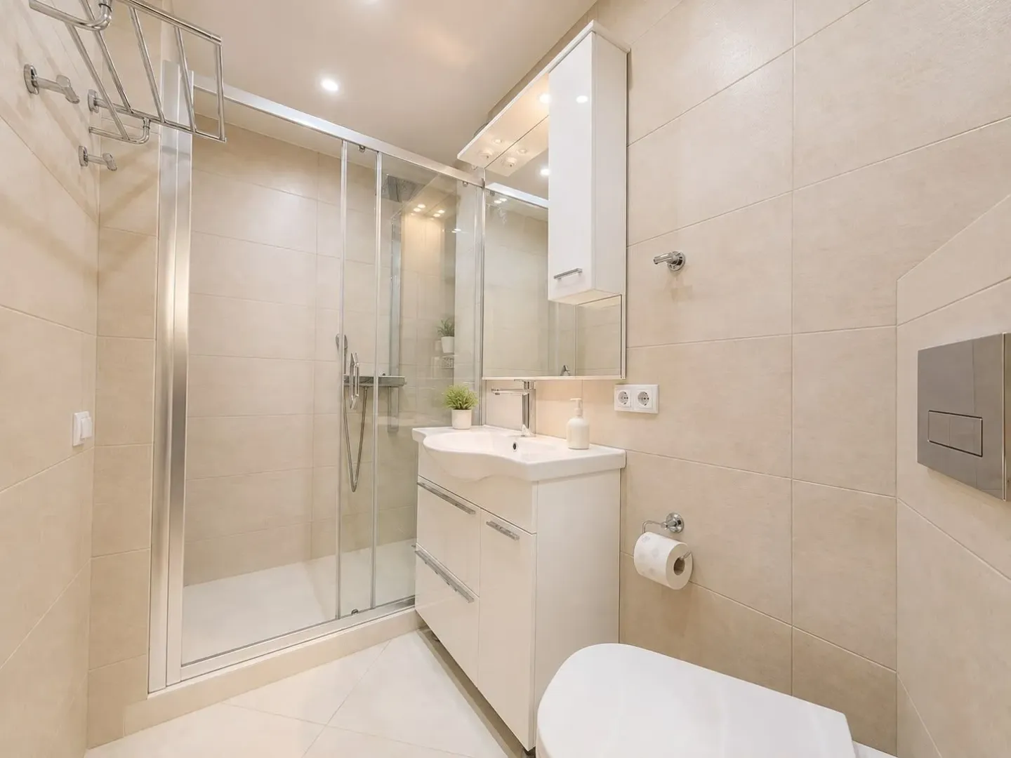 Modernly equipped bathroom with a walk-in shower and white sanitary ware.
