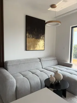 Moderan dnevni boravak sa udobnom ugaonom garniturom, stočićem i dekorativnom slikom na zidu. - image 4