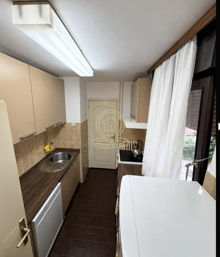 Small kitchen with wooden cabinets and appliances.