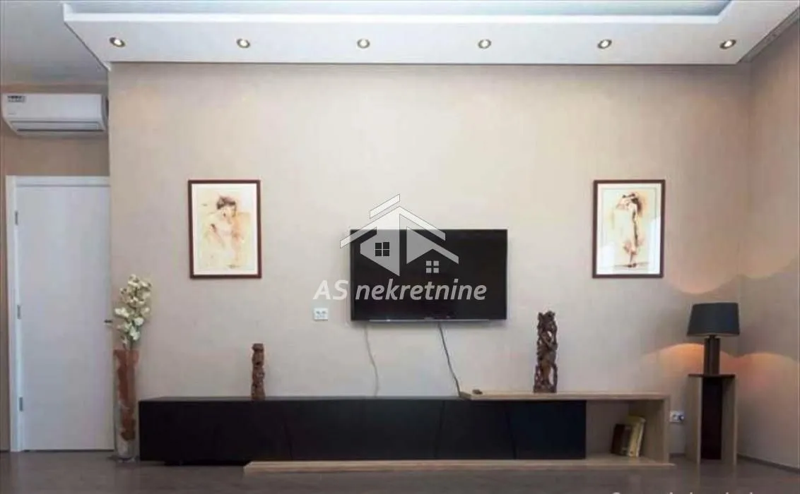 View of the wall with a television and a cabinet in the living room.